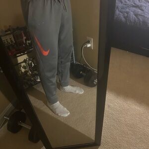 Gray dri fit Nike Joggers with orange Swoosh